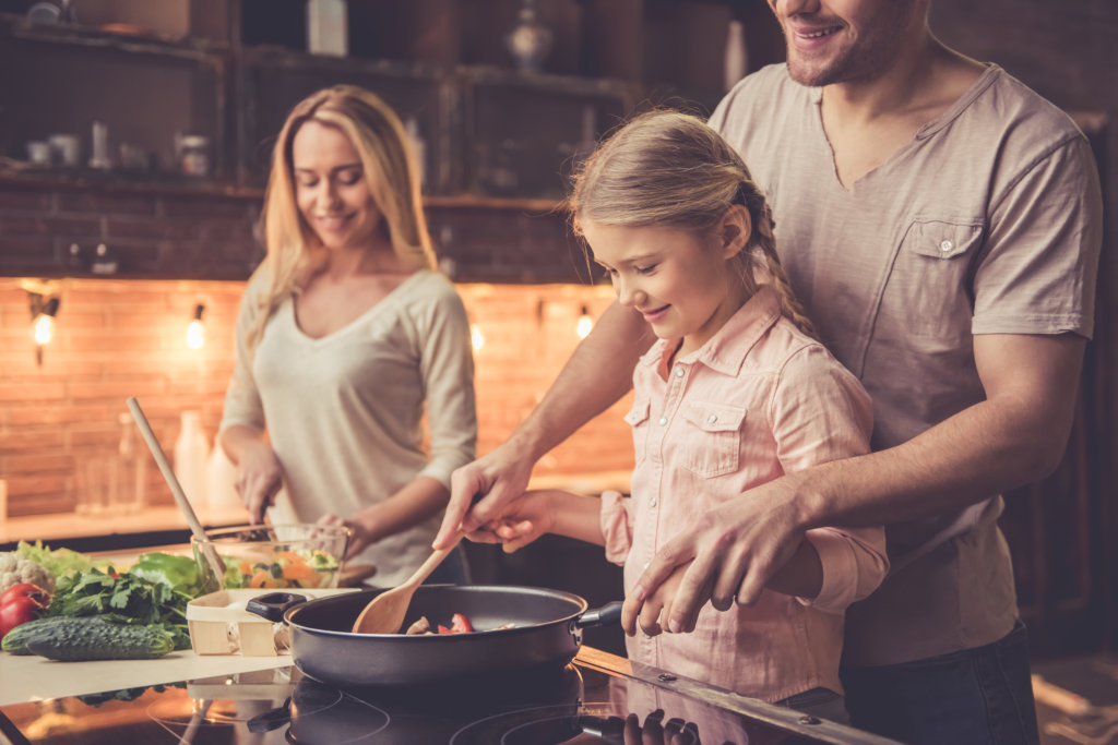Familienabend Ideen: Eltern und Tochter kochen gemeinsam